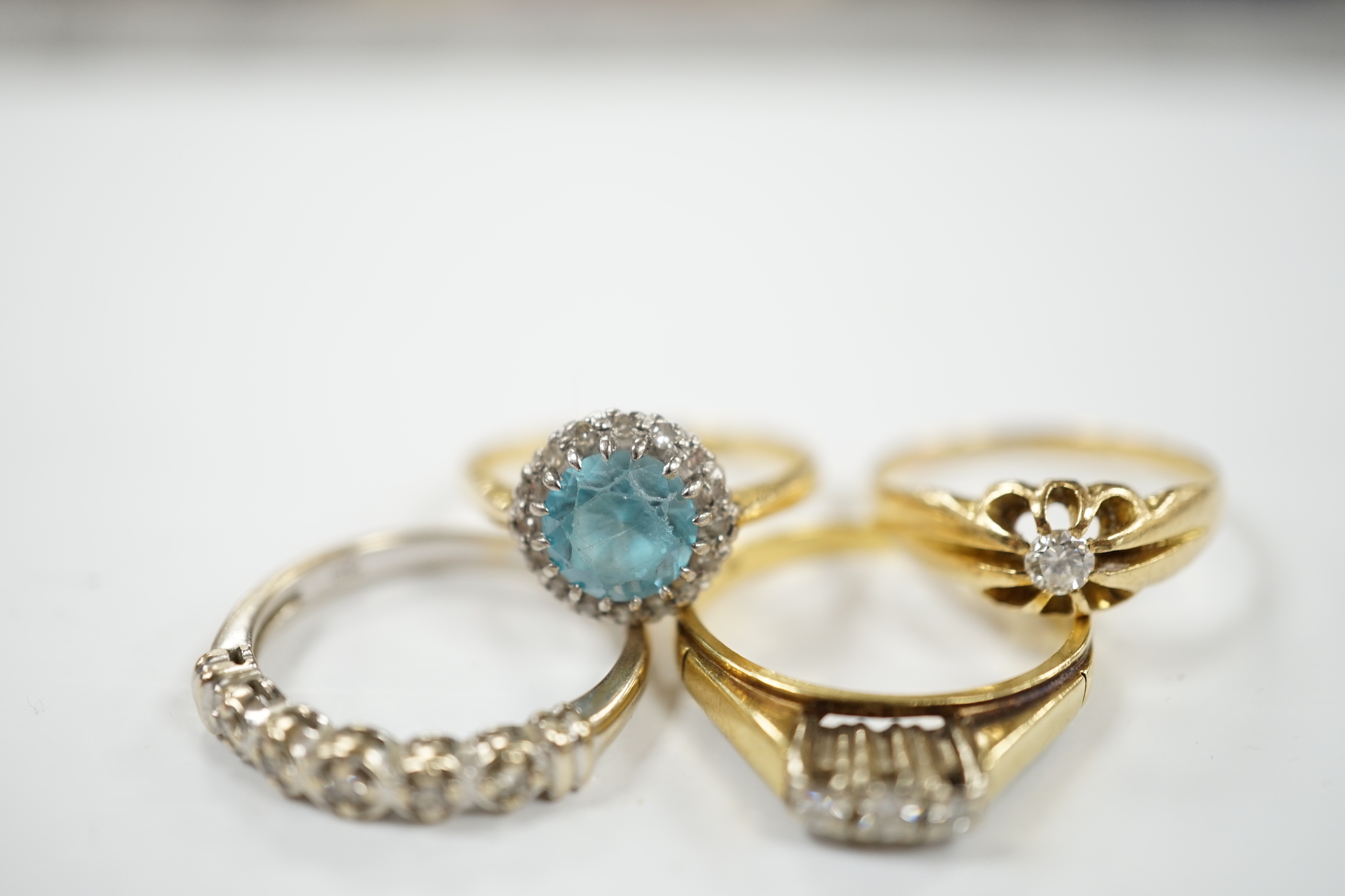 Three assorted 18ct and gem set dress rings, including blue zircon and diamond chip and claw set solitaire and one other yellow metal and gem set ring, gross weight 12.6 grams.